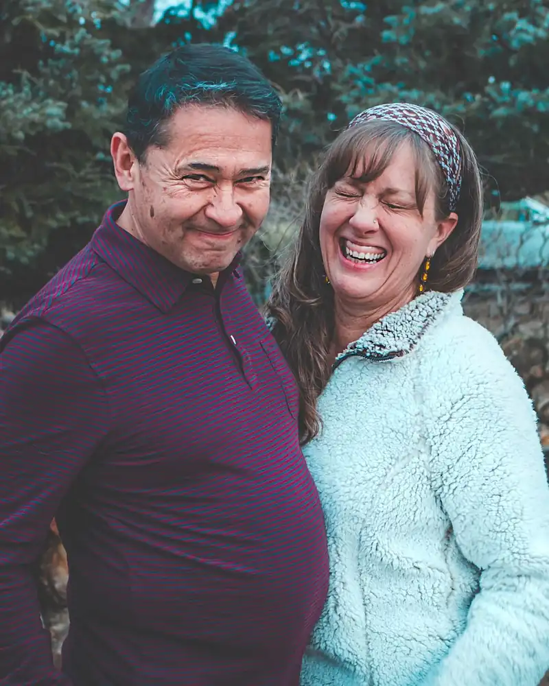 A man and woman laughing together, warm and full of life.